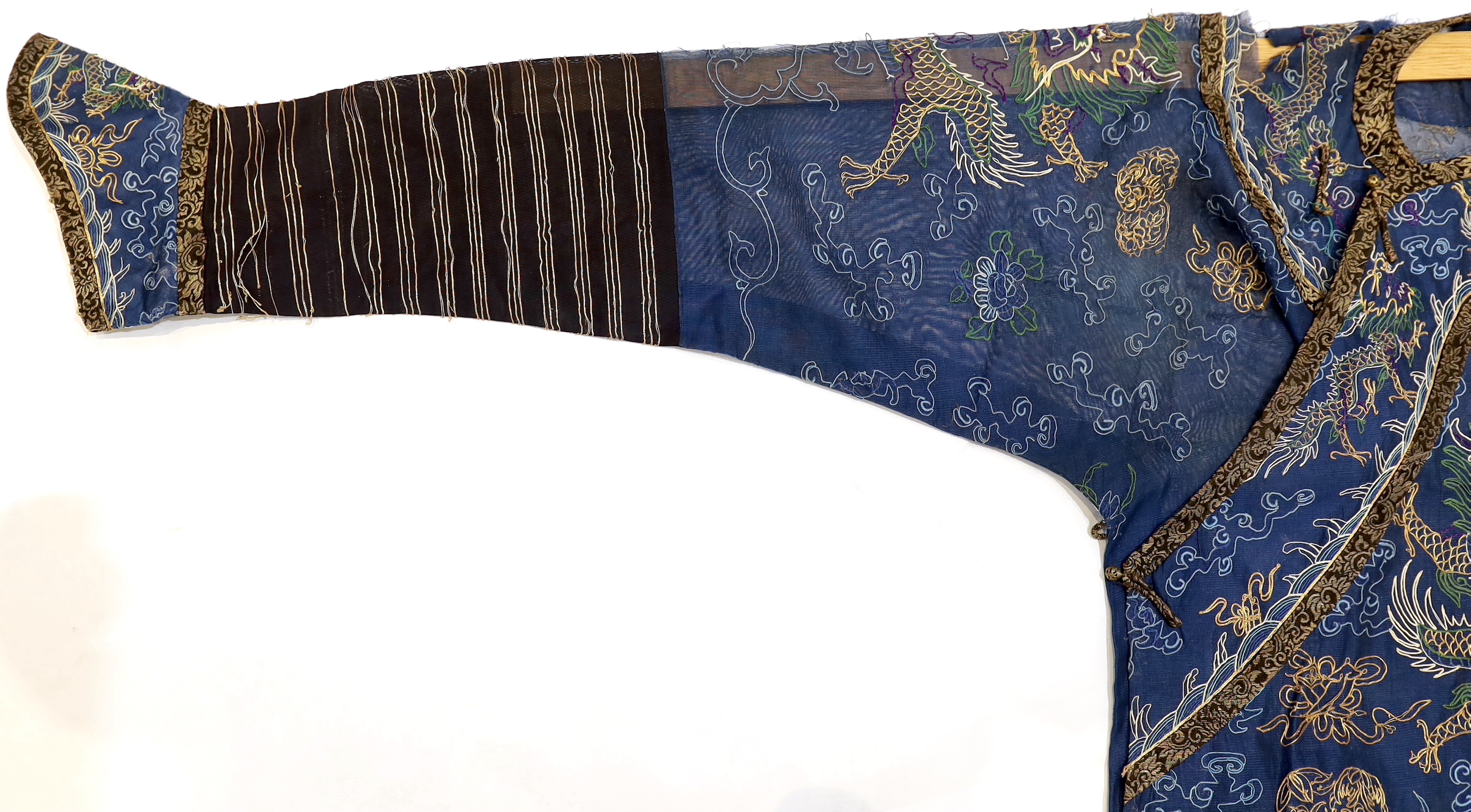 A Chinese fine blue gauze summer robe embroidered with a gold thread dragon highlighted by coloured silk embroidery together with a similar gauze panel embroidered with dragons, 163cm x 75cm